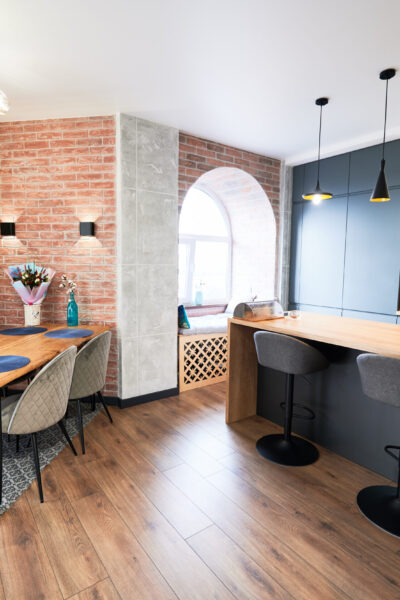 Living room and kitchen studio in dark blue color with modern furniture table, chair and stylish lamps. Concept of stylish modern interior kitchen with bar table.