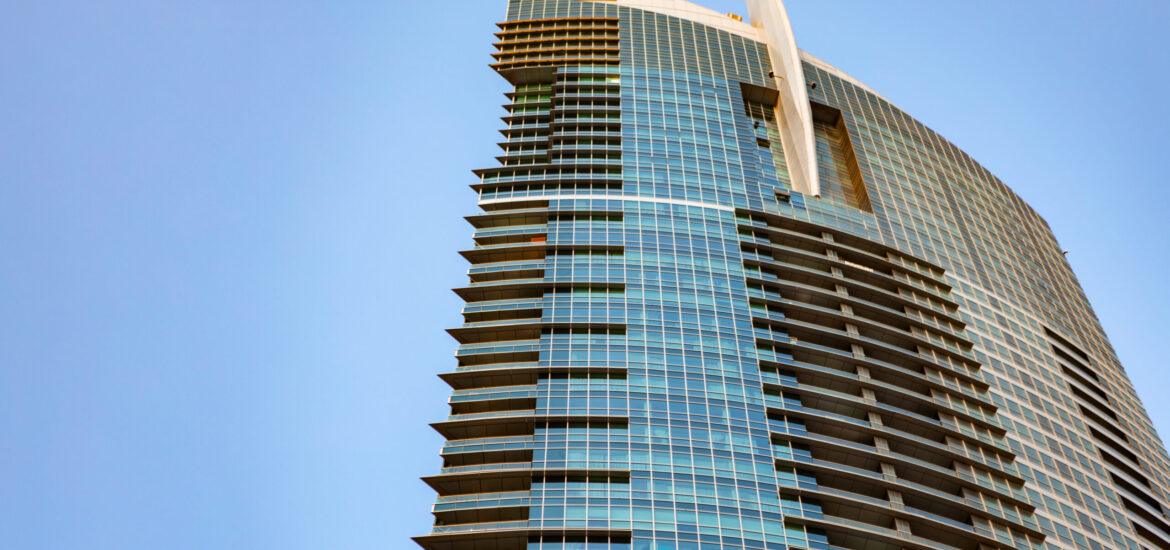 Glass skyscraper against blue sky, view from the bottom