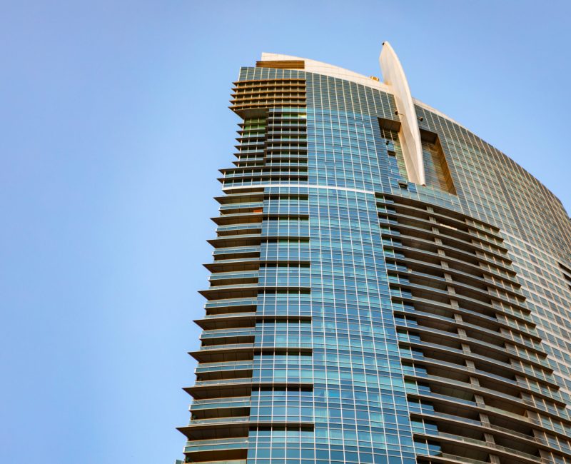 Glass skyscraper against blue sky, view from the bottom